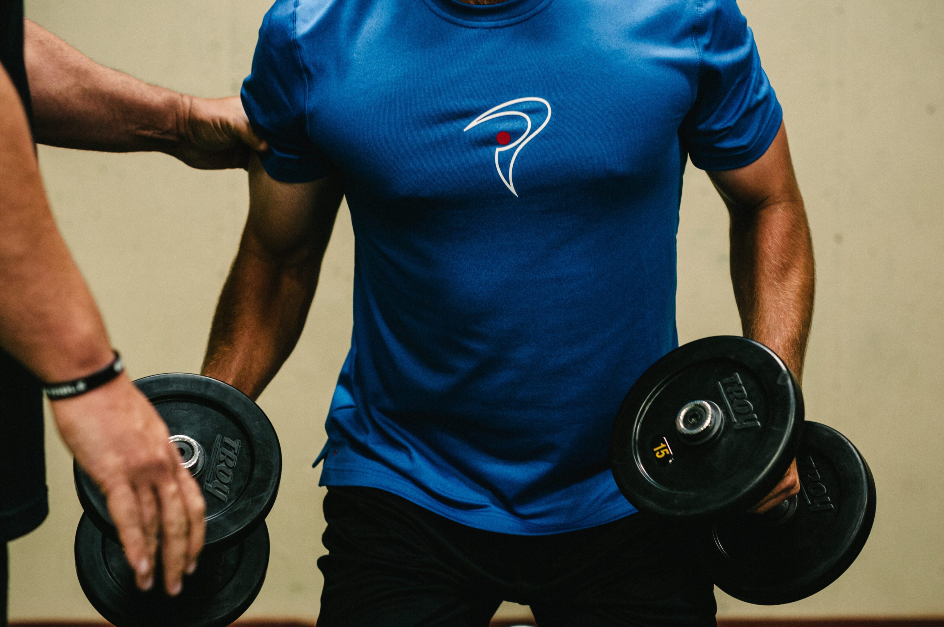 Person in blue shirt doing dumbbell lunges