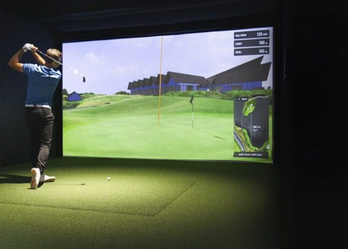 Person swinging in indoor golf simulator